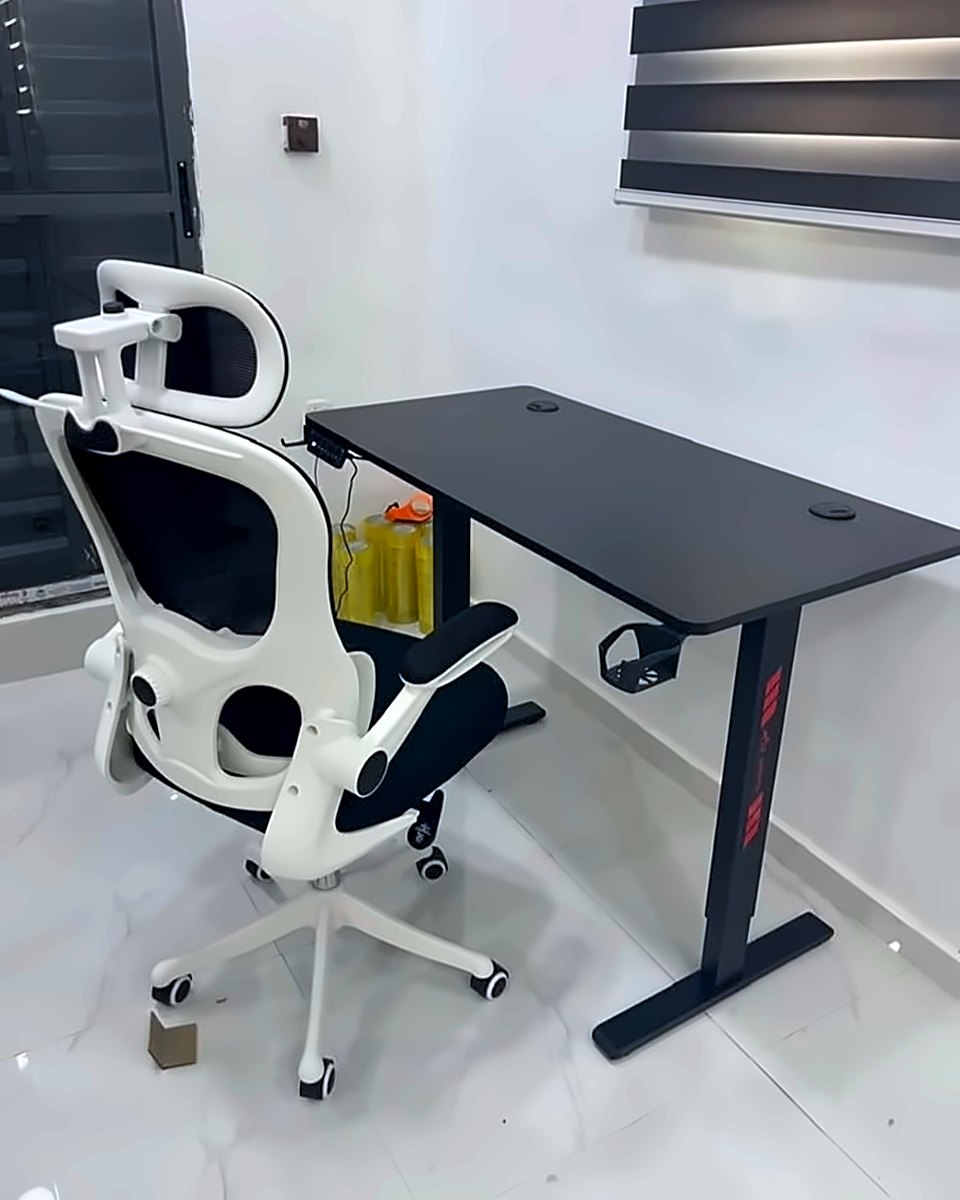White ergonomic mesh chair at a black desk in a bright room